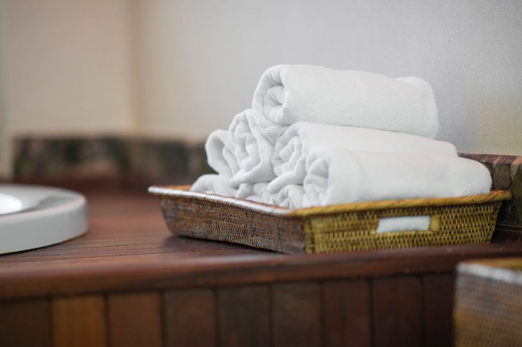 pexels-photo-4177714 Rolled white towels neatly placed in a woven basket, perfect for spa or bathroom decor.